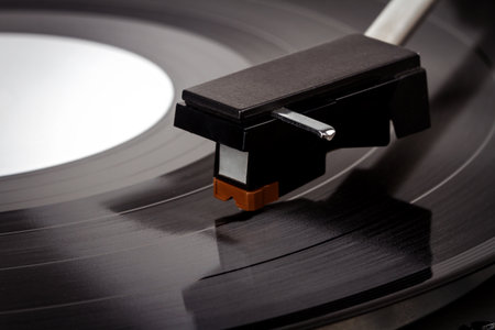 Close up of turntable needle on a vinyl record. Turntable playing vinyl. Needle on rotating black...