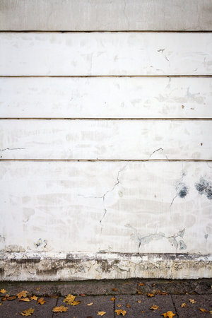 Aged weathered lined plaster white street wall . Architecture detail background