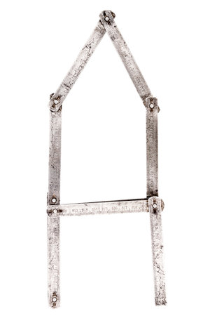 Old iron meter ruler. Old iron folding meter in the shape of letter A isolated on white background.の写真素材