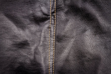 Crumpled black leather texture background. Abstract texture of leather with a seam.の写真素材