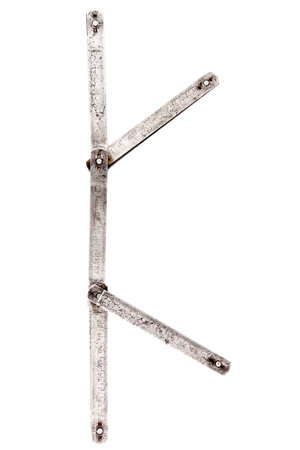 Old iron meter ruler. Old iron folding meter in the shape of letter K isolated on white background.の写真素材