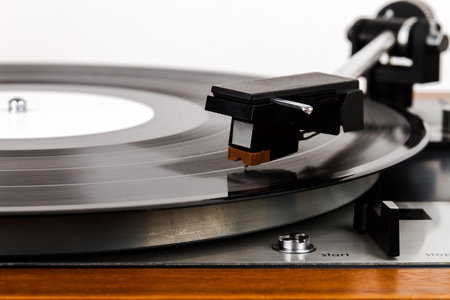 Close up of turntable needle on a vinyl record. Turntable playing vinyl. Needle on rotating black...