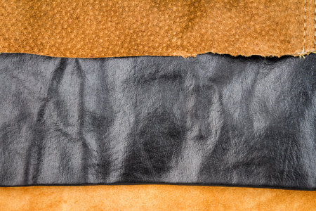 Genuine brown and black leather textures background. Abstract vintage natural cow skins backdrop. Different leather stripes.の写真素材