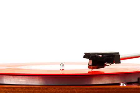 Close up of turntable needle on a vinyl record. Turntable playing music. Stylus on rotating red...