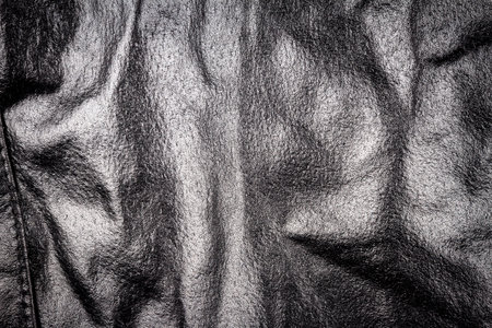 Crumpled black leather texture background. Abstract texture of leather with a seam.の写真素材