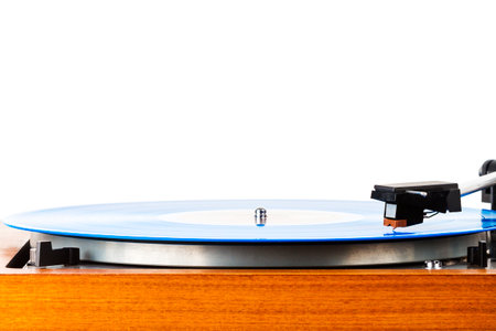Close up of vintage turntable vinyl record player isolated on white. Wooden plinth. Retro audio...