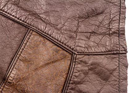 Piece of brown leather isolated on white background. Crumpled material texture.