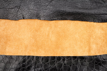 Brown and black leather and artificial alligator skin textures background.
