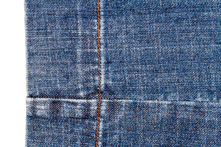 Piece of dark blue jeans fabric isolated on white background. Rough uneven edges.