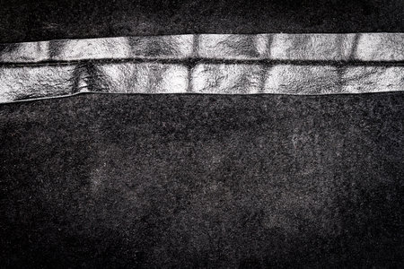 Crumpled black leather texture background. Abstract texture of leather with a seam. Back side