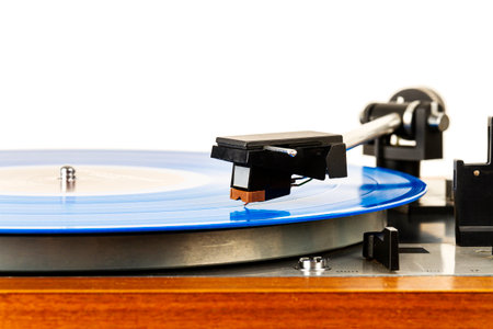 Close up of vintage turntable vinyl record player isolated on white. Wooden plinth. Retro audio...