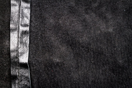 Crumpled black leather texture background. Abstract texture of leather with a seam. Back side