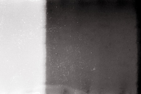 Noisy film frame with heavy scratches, dust and grain. Abstract old film backgroundの写真素材