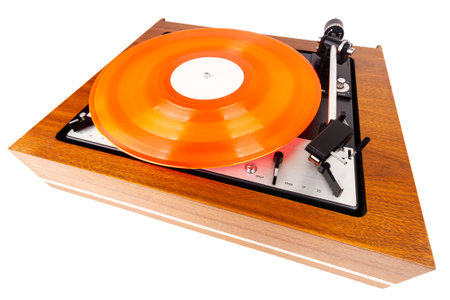 Vintage turntable with a red vinyl isolated on white. Wooden plinth. Retro audio equipment.の写真素材
