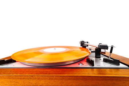 Vintage turntable with a red vinyl isolated on white. Wooden plinth. Retro audio equipment.の写真素材