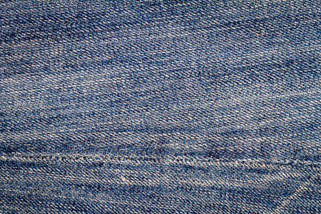 Blue jeans texture. Denim fabric background with a seam.の写真素材