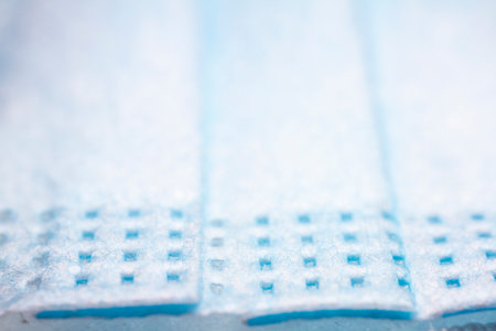 Protective, disposable light blue face mask. Extreme close-up macro photography. Selective focus.
