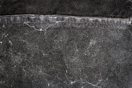Crumpled black leather texture background. Abstract texture of leather with a seam. Grungy back side