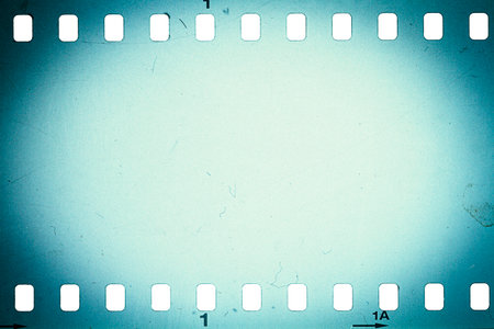 Dusty and grungy 35mm film texture or surface. Perforated camera film isolated on white background.の写真素材