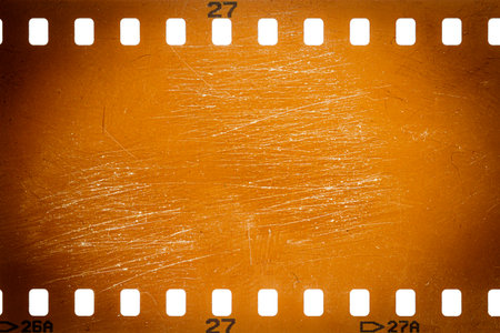 Dusty and grungy 35mm film texture or surface. Perforated camera film isolated on white background.の写真素材