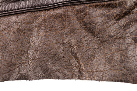 Piece of brown leather isolated on white background. Crumpled material texture.