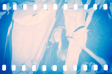 Dusty and grungy 35mm film texture or surface. Perforated scratched camera film isolated on white background.の写真素材