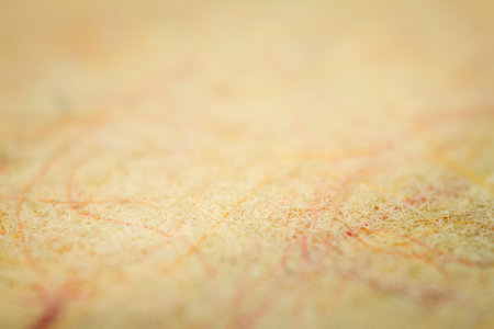 Extreme closeup of yellow handmade paper with shallow depth of field.の写真素材