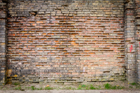 Old weathered wall of bricks and a sidewalkの写真素材
