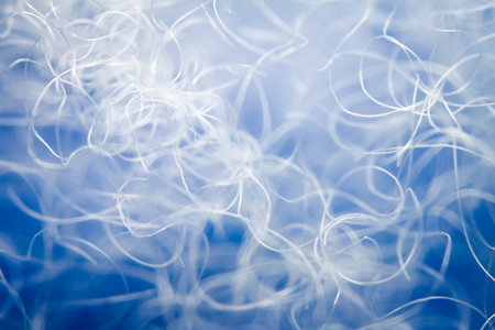 Extreme macro of polyester stable fiber on blue background. Selective focus, shallow depth of field....