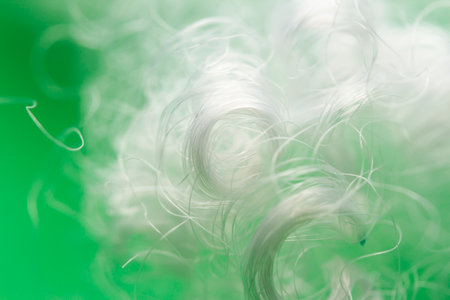 Extreme macro of polyester stable fiber on green background. Selective focus, shallow depth of field. Abstract dreamy backgroundの写真素材