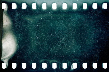 Dusty and grungy 35mm film texture or surface. Perforated scratched camera film isolated on white background.の写真素材
