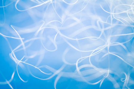 Extreme macro of polyester stable fiber on blue background. Selective focus, shallow depth of field. Abstract dreamy backgroundの写真素材