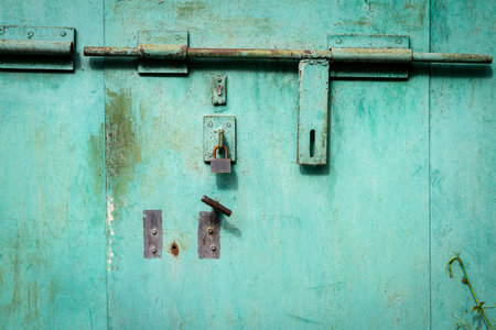 Old green grunge metal door with padlock