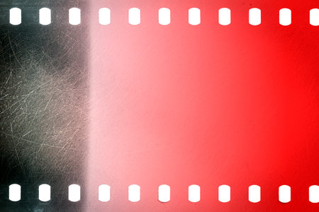 Dusty and grungy 35mm film texture or surface. Perforated scratched camera film isolated on white background.の写真素材