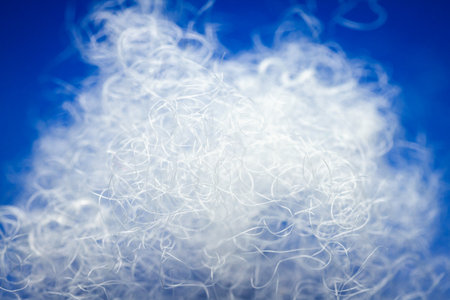 Extreme macro of polyester stable fiber on blue background. Selective focus, shallow depth of field. Abstract dreamy backgroundの写真素材
