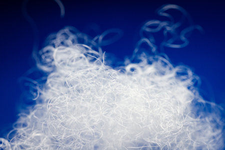 Extreme macro of polyester stable fiber on blue background. Selective focus, shallow depth of field. Abstract dreamy backgroundの写真素材