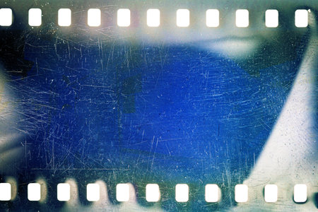 Dusty and grungy 35mm film texture or surface. Perforated scratched camera film isolated on white background.の写真素材