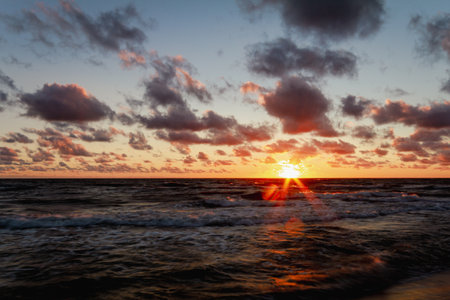 Beautiful sunset with clouds sea and beach, long exposure shotの写真素材