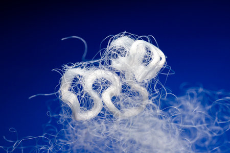 Extreme macro of polyester stable fiber on blue background. Selective focus, shallow depth of field. Abstract dreamy backgroundの写真素材