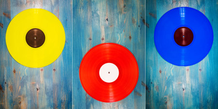 Collection of images with different color vinyl records on blue wooden backgroundの写真素材