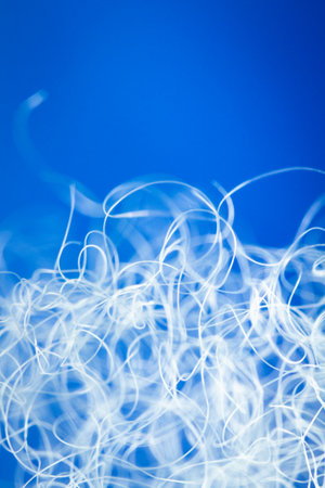 Extreme macro of polyester stable fiber on blue background. Selective focus, shallow depth of field. Abstract dreamy backgroundの写真素材