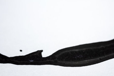 Extreme close up of black acrylic paint texture on paper. Selective focus.の写真素材