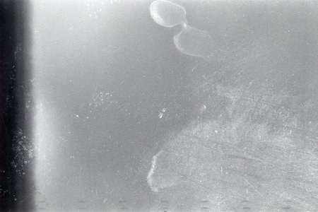 Blank grained film strip texture background with heavy grain, dust and finger printsの写真素材