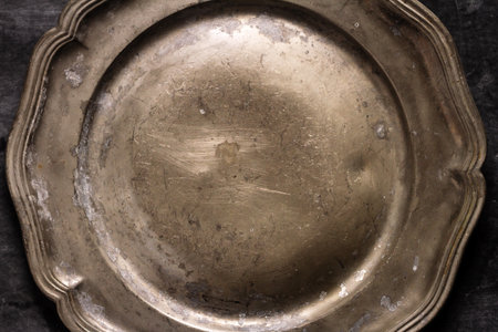 Close up of vintage pewter plate on black chalkboard background. Flat lay. Top view. Food concept. Dark mood food photography.の写真素材