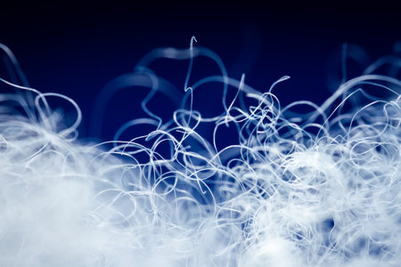 Extreme macro of polyester stable fiber on blue background. Selective focus, shallow depth of field....