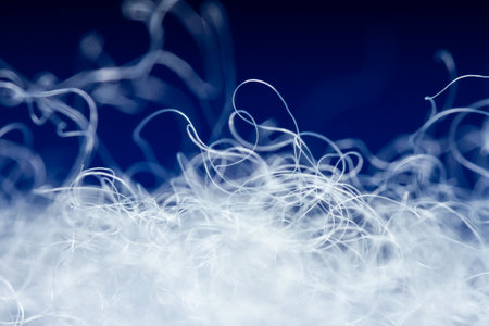 Extreme macro of polyester stable fiber on blue background. Selective focus, shallow depth of field. Abstract dreamy backgroundの写真素材