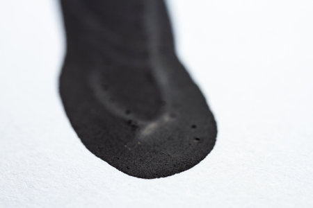 Extreme close up of black acrylic paint texture on paper. Selective focus.の写真素材