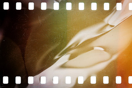 Dusty and grungy 35mm film texture or surface. Perforated scratched camera film isolated on white background.の写真素材