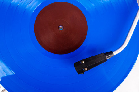 Close up of turntable needle on a vinyl record. Turntable playing vinyl. Needle on rotating blue vinyl.の写真素材