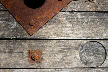 An old and cracked wooden panels with rusty nut and bolt in it as a background